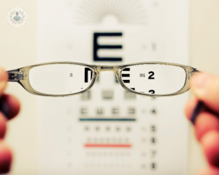 Holding glasses up to an eye test