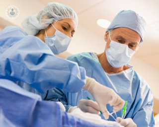 Woman and man surgeons performing a procedure in an operating theatre