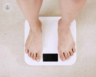 Two feet standing on a digital weight scale. Gastric sleeve surgery results in rapid weight change.