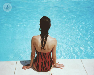 Girl sat at the side of a pool 