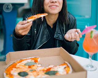 woman eating pizza and smiling 