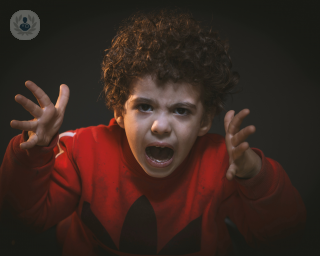 Toddler looking angry and shouting using his hands