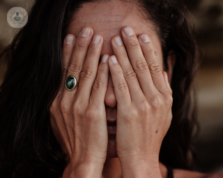 Woman with her hands covering her face
