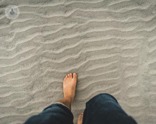 A person's foot on the beach