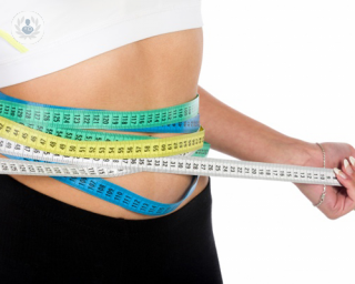 Waist of woman who has lost weight with tape measures