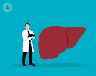 A doctor standing beside a big liver diagram.