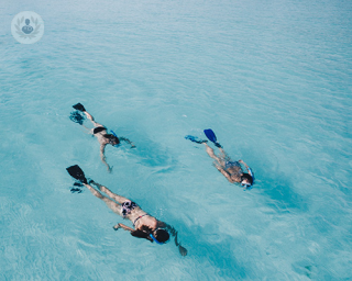 three people snorkelling in the sea