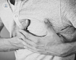 Man who requires coronary angioplasty holding chest