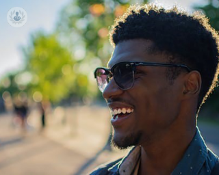 a man smiling wearing sunglasses