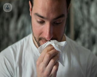 A man with sinus problems blowing his nose