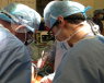 Two surgeons, one of which being Mr Mihai, performing surgery for ACC. Only the surgeons and tools are visible.