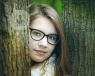girl in glasses, head between to trees