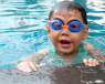 Chid wearing blue goggles in a pool