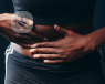 Woman holding the right side of her stomach with both hands 