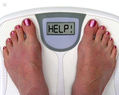 Person who needs bariatric surgery on weighing scales