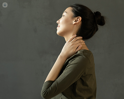 Woman with hand on neck and thoracic area.