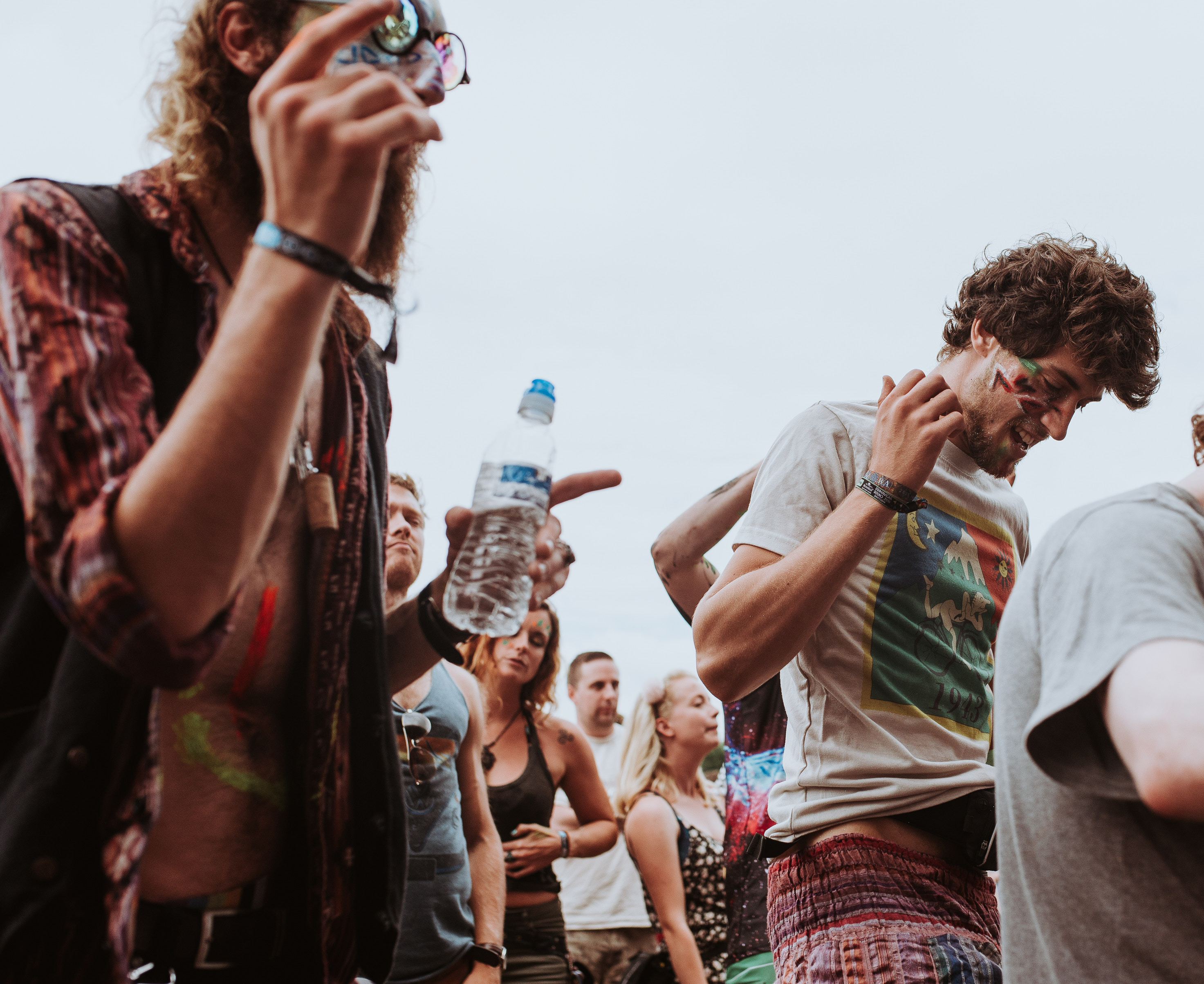 Festival-goers dancing to live music and drinking water. How to survive a music festival tip 2: stay hydrated!