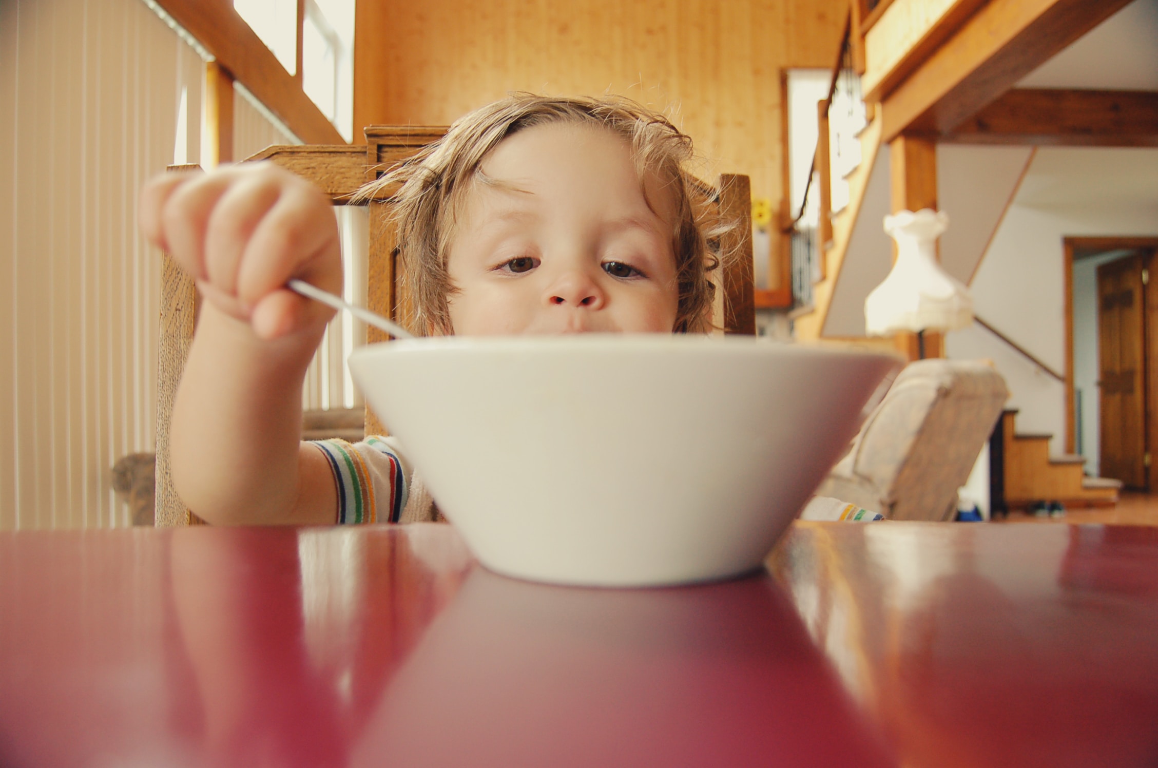 Small child eating their meal from a bowl