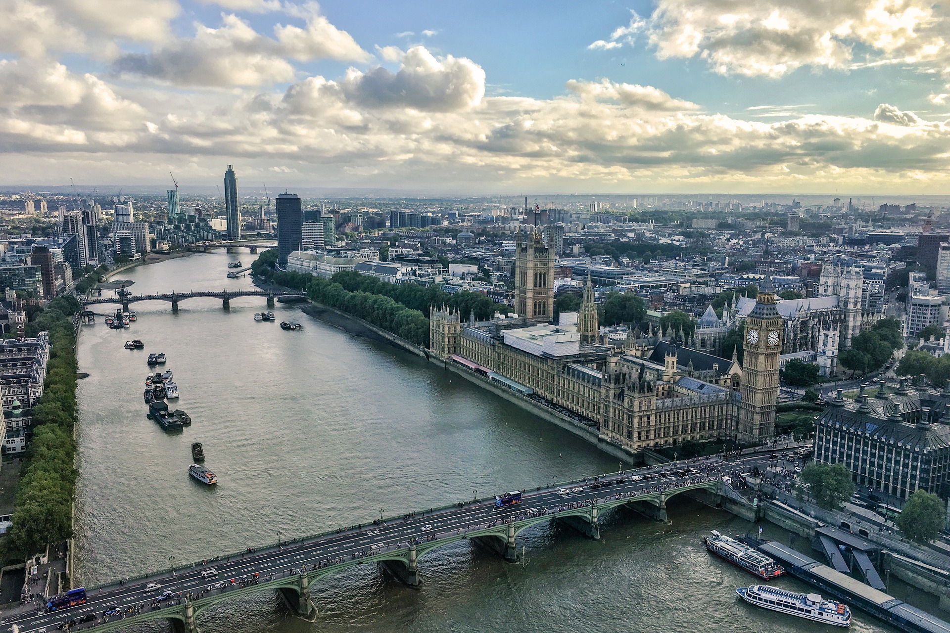 A view of central London with a focus on the River Thames. Harley Street can be found in the borough of the City of Westminster. In the image, the Palace of Westminster is to the right side of the river, and buildings span until the horizon line.