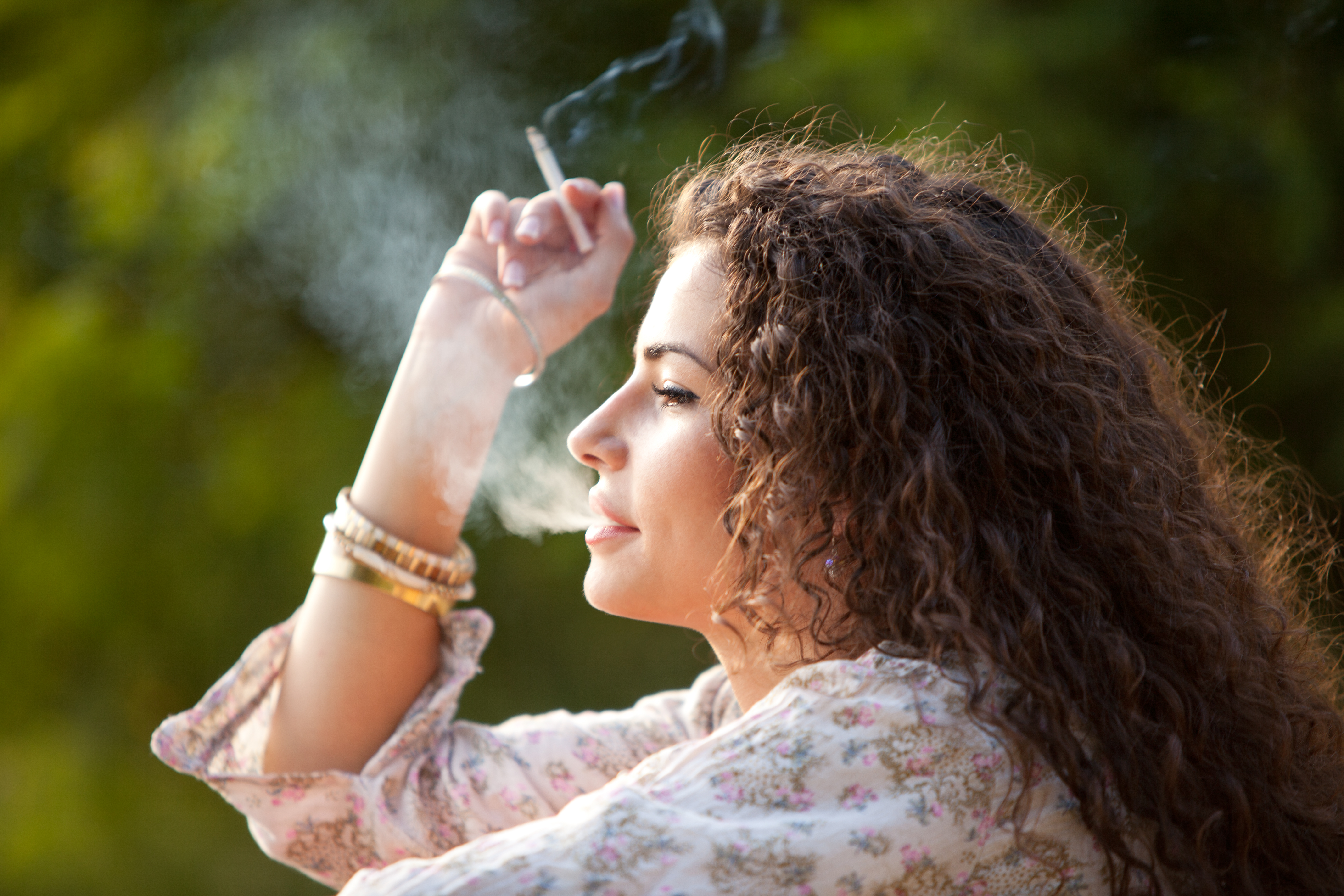 A young woman smoking outside. Breast cancer research has identified that tabacco is one of the top contibutors. Advances like this allow us to change our lifestyle and lower our risk of developing breast cancer.