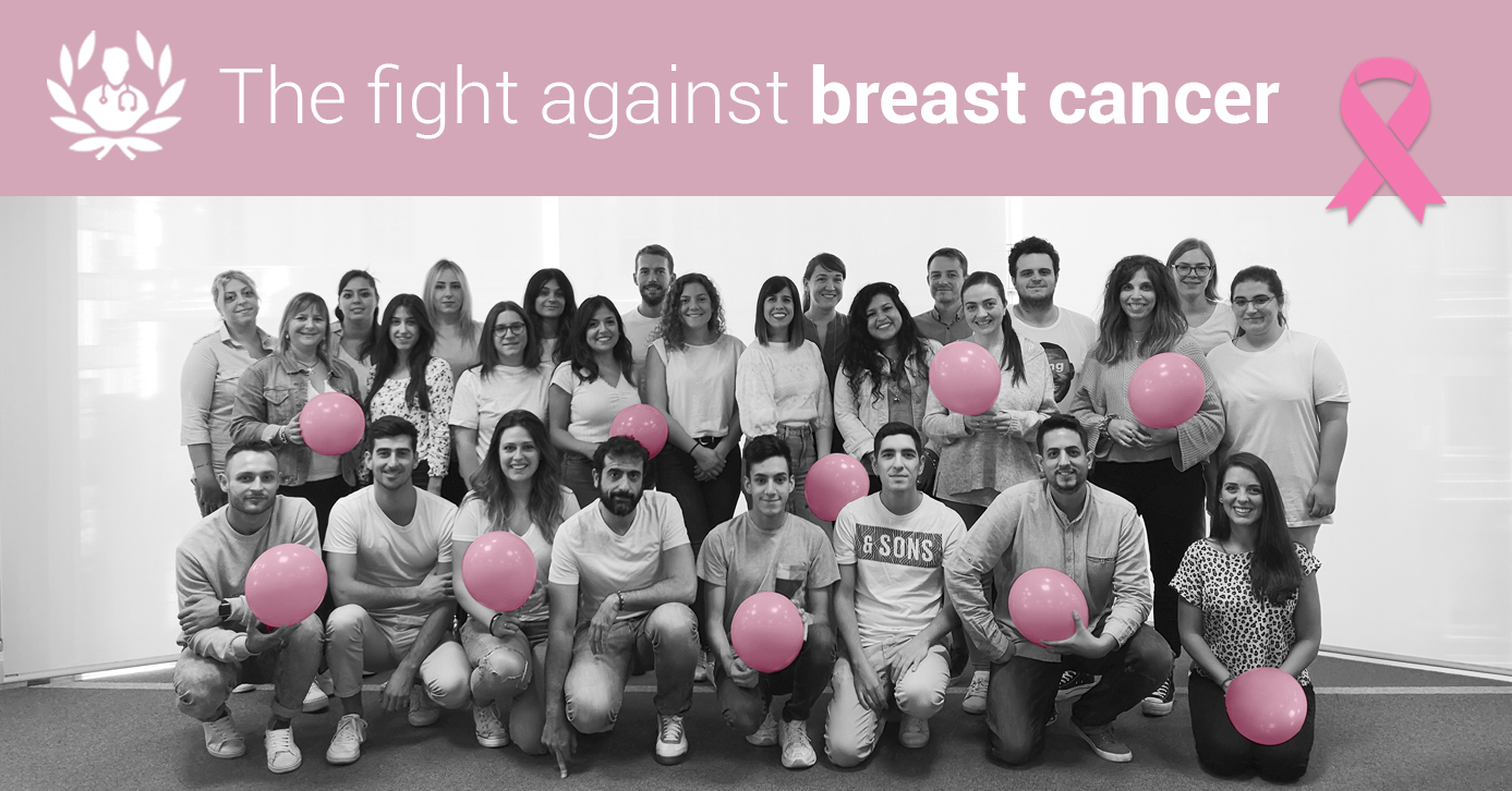 A black and white photo of members of the Top Doctors team in support of Breast Cancer Awareness Month. Some of them are holding bright  pink balloons which stand out from the black and white background. They are thinking pink for breast cancer awareness.