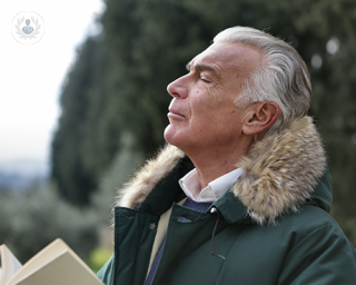 An older man looks upwards as he catches his breath. Shortness of breath, or air hunger, can be a symptom of heart problems.