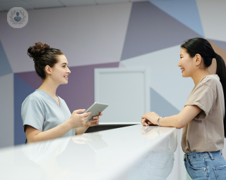 Woman talking to a receptionist at a clinic
