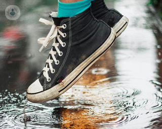 Person wearing converse, in a puddle