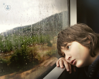 A child with ADHD looking out the window.