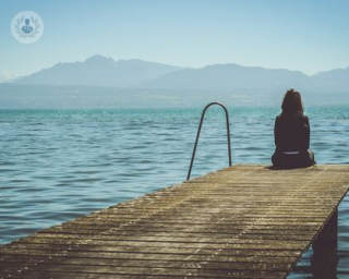 A very pensive woman by a lake.