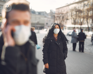 Two people in the street wearing face masks
