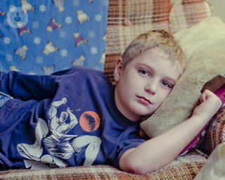 A boy lying on a couch.