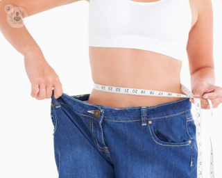 A woman who has lost weight wearing jeans she had before weight loss