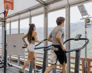 A man and woman running on treadmills
