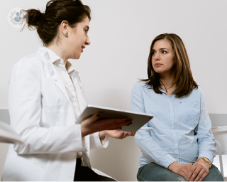 A patient at a gynaecological consultation, discussing her procedure findings with the doctor.