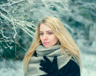 blonde haired woman in the snow wearing a scarf