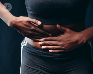 An image of a women holding her stomach