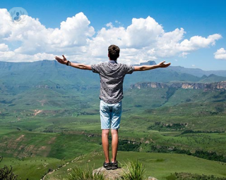Man standing out onto a mountain looking out at the views