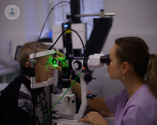 An elderly man undergoing an eye examination with an ophthalmologist.