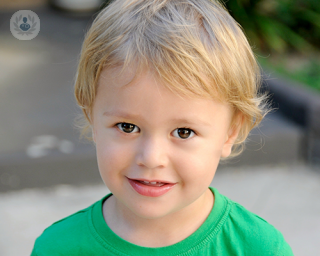 A young blond boy wearing a green t-shirt