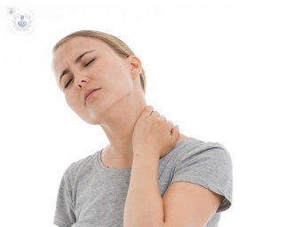 Woman in pain holding her neck.