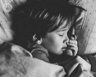 A black and white pic of a child sleeping, 