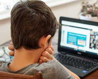 A young boy having difficulty concentrating and focusing on an online lesson.