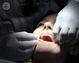 Woman in the dentist chair with her mouth open.