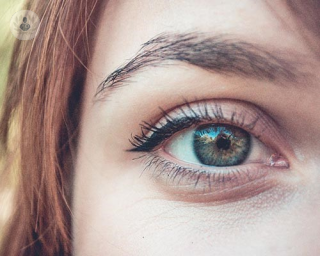 woman with blue green eye and red hair 