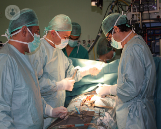 A surgical team in an operating theatre performing a spinal fusion.