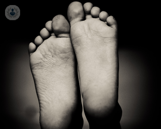 A black and white photo of the soles of two feet