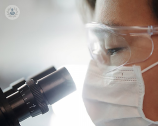 an image of a surgeon looking through a microscope