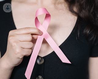 Woman holding the pink breast cancer symbol