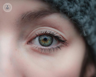 A shot of woman's eye, a woman who is wearing a beanie